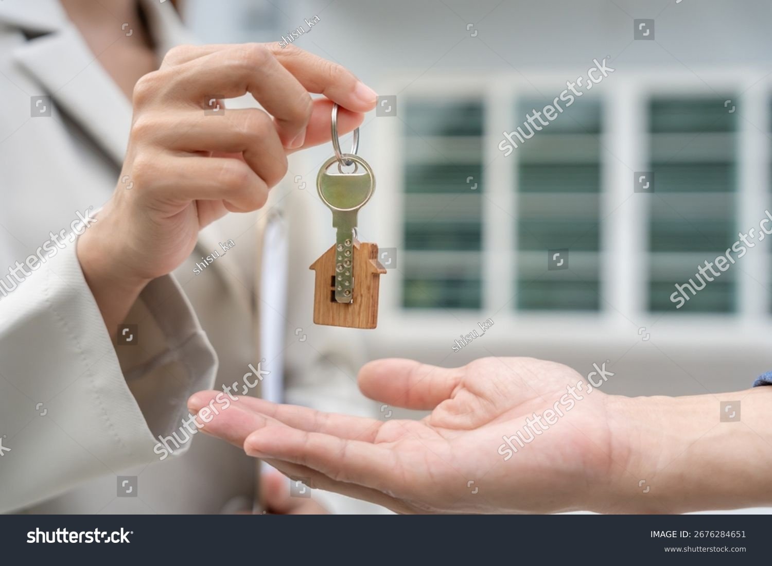 stock-photo-lease-rental-and-selling-home-real-estate-agent-manager-smile-holding-key-for-new-owner-rent-2676284651