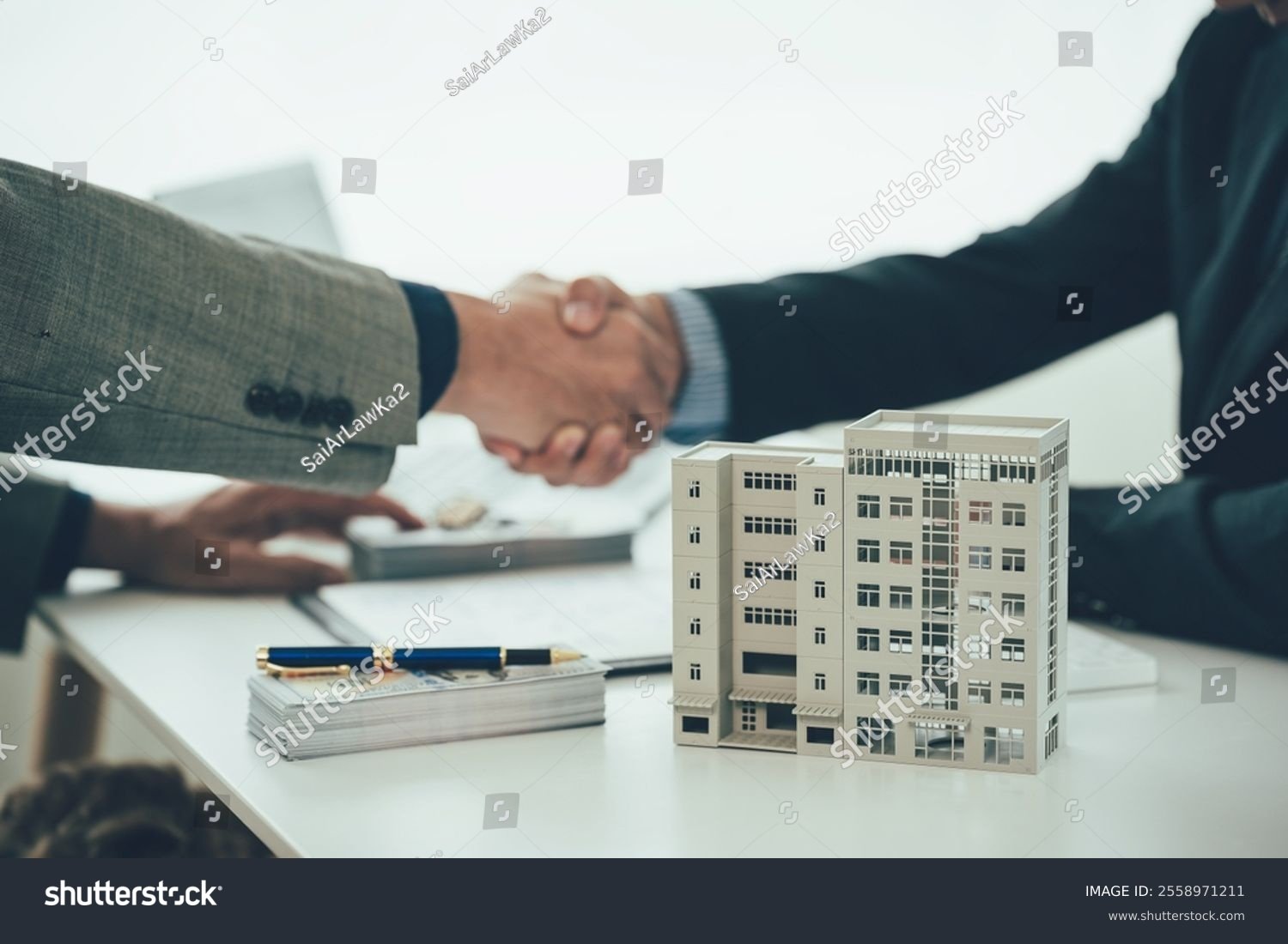 stock-photo-two-businessmen-holding-hands-at-the-table-represents-a-successful-real-estate-deal-close-up-of-2558971211